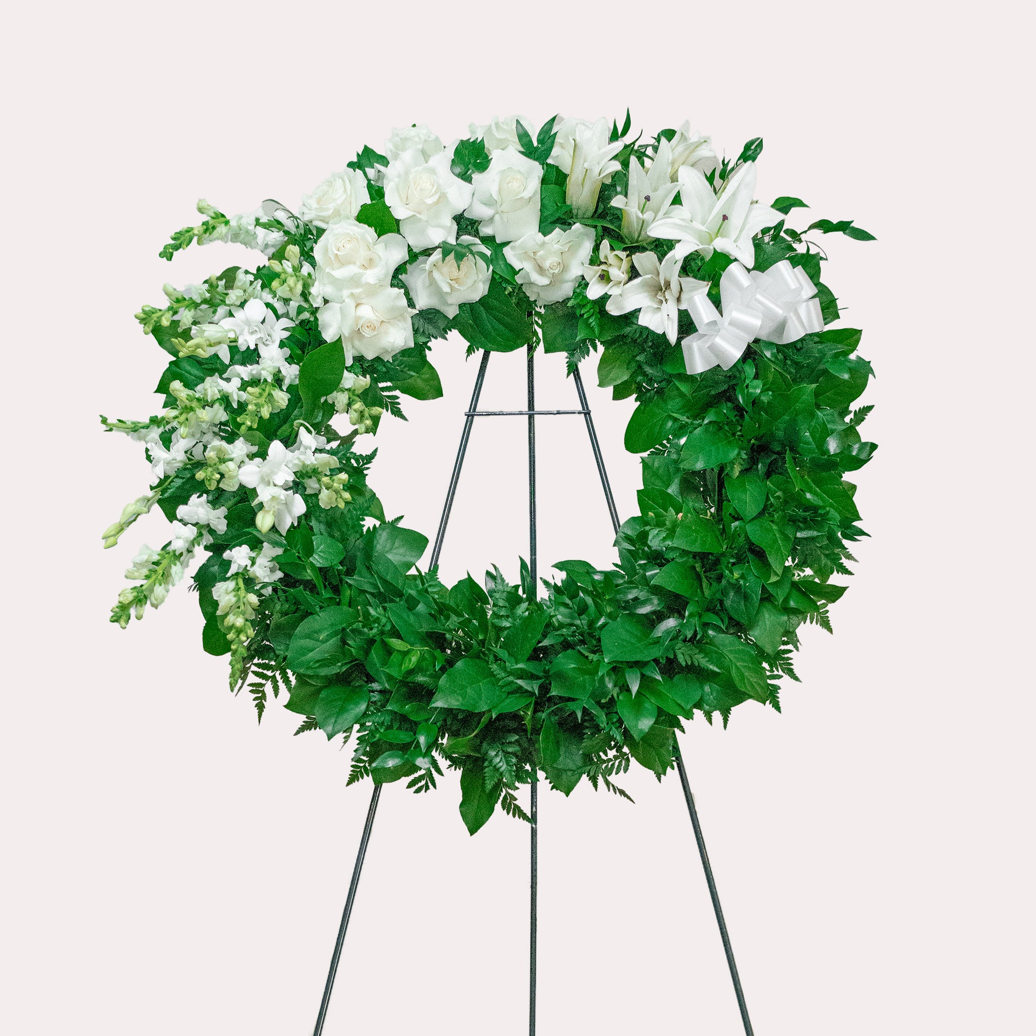 a sympathy wreath of all white and lush greens